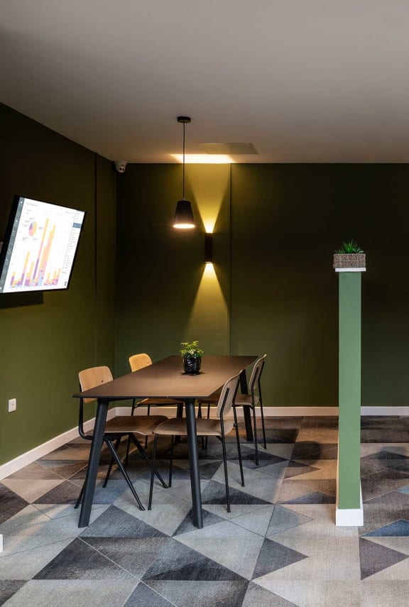 a dining room with green walls and a table and chairs