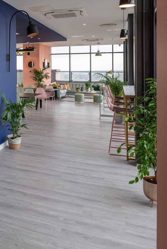 the lobby of a restaurant with plants and tables