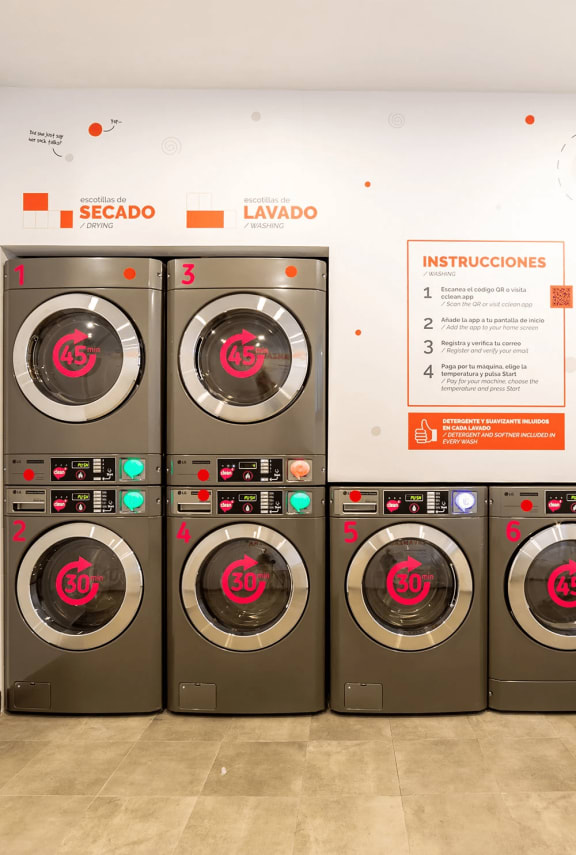 a row of washers and dryers in a laundry room