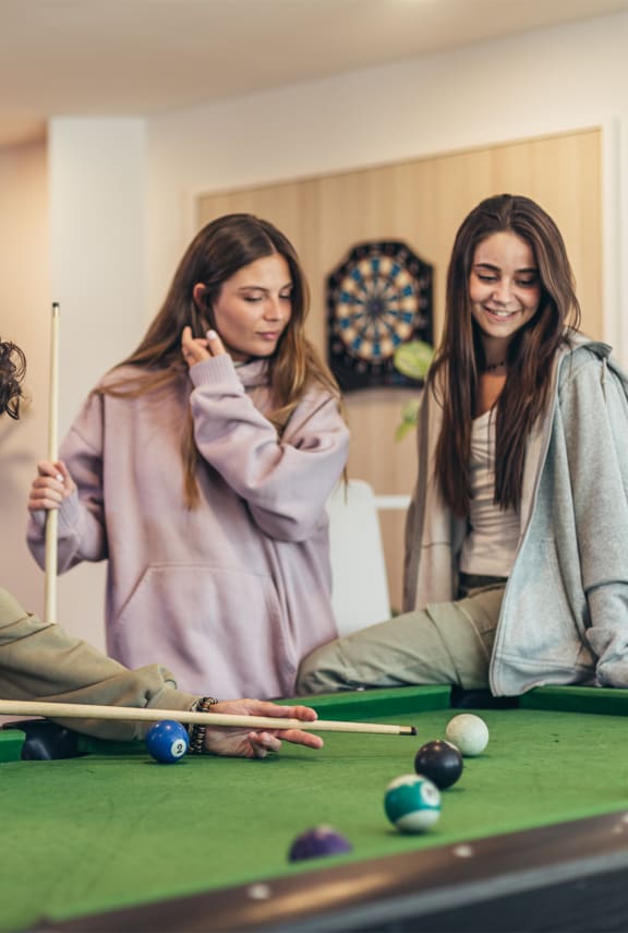 a games room with a pool table and a dart board