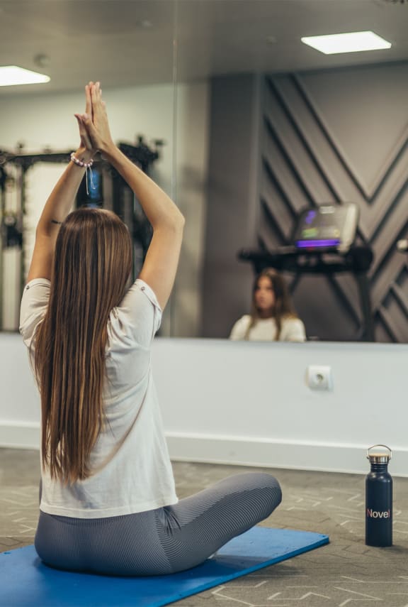 two treadmills and weights in a workout room with a white wall and white