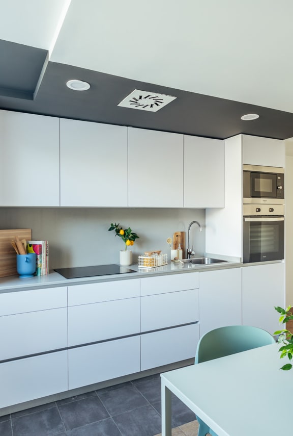 a white kitchen with white cabinets and a table