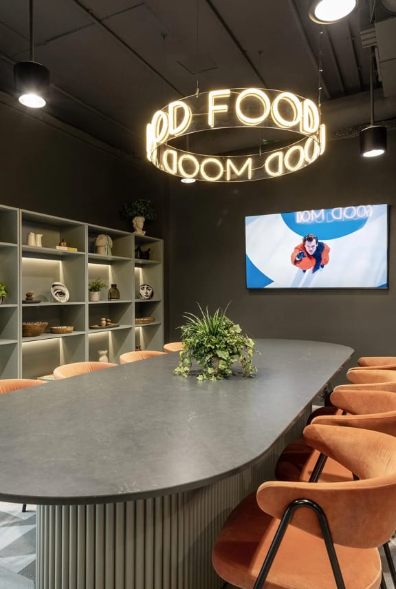 a large table in a room with chairs and a tv