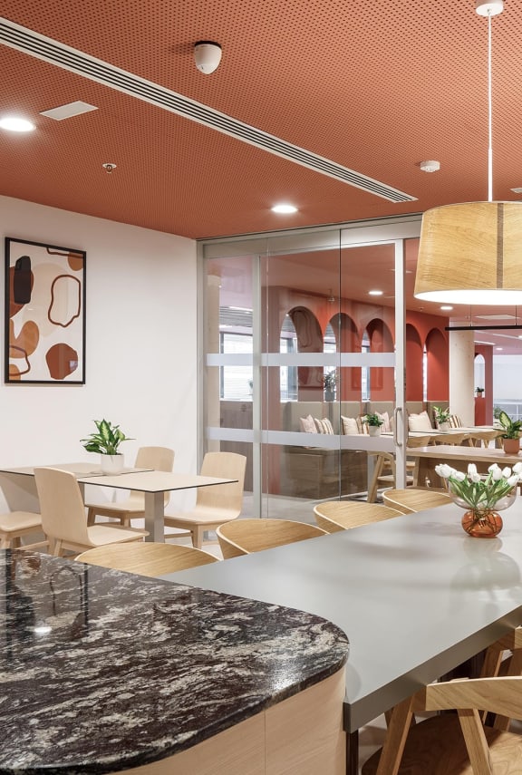 a dining room with tables and chairs and a glass wall