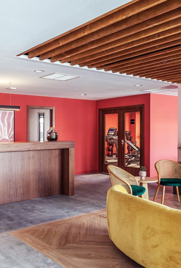 the lobby of a hotel with a reception desk and chairs
