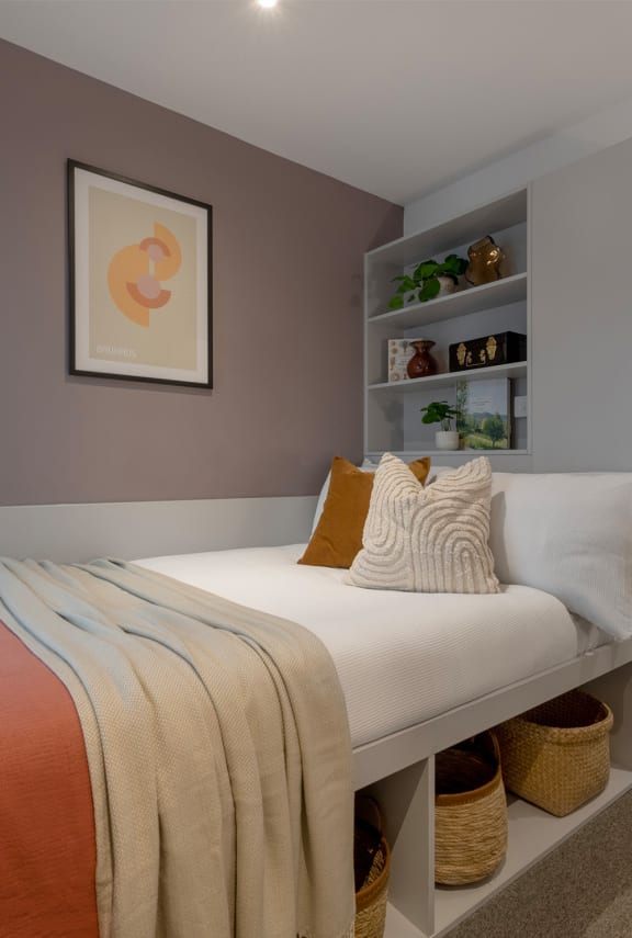 a small bedroom with a bed and a shelf