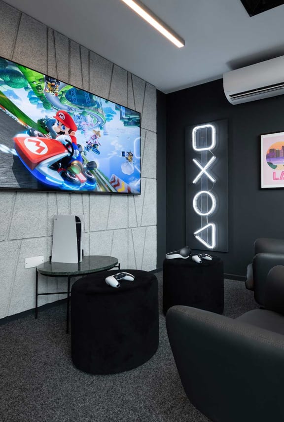 a room with a tv and some chairs and a table