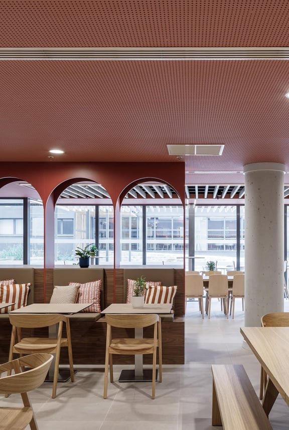 a restaurant with a red ceiling and tables and chairs