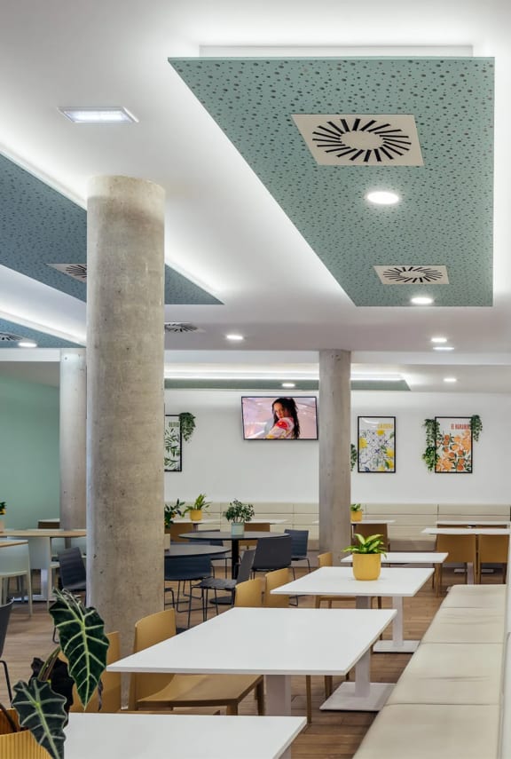 a restaurant with white tables and chairs and a large pillar