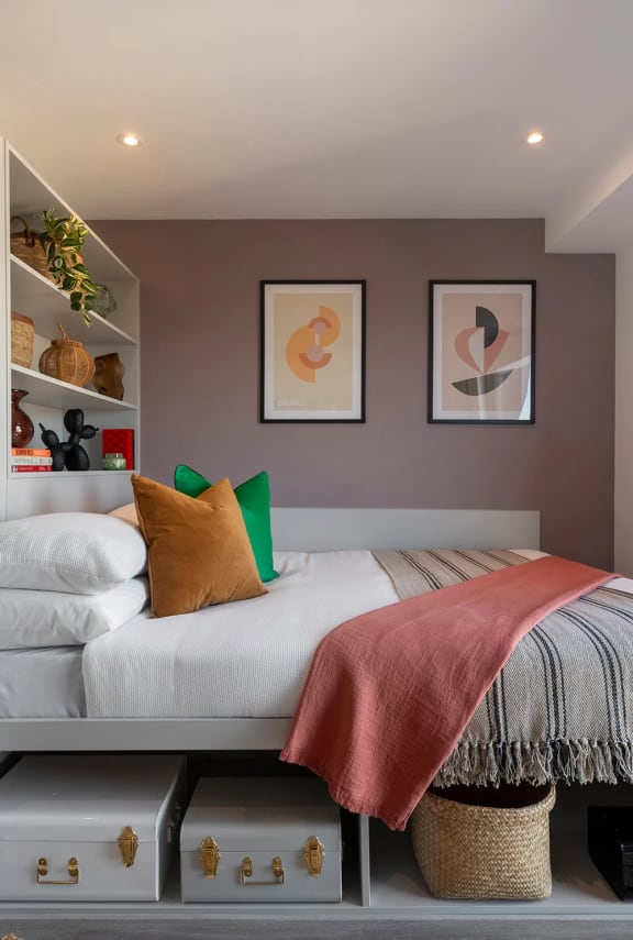 a bedroom with a bed and a shelf with pillows on it