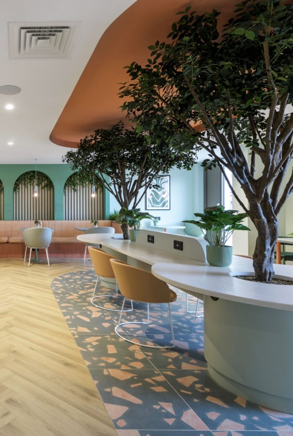 a rendering of a lounge area with tables and chairs and plants