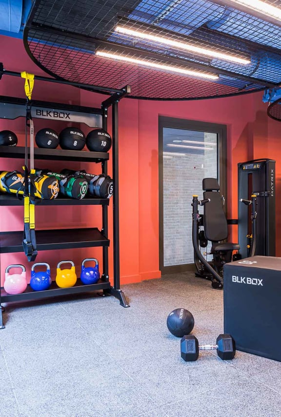 a gym with luggage on the floor and exercise machines