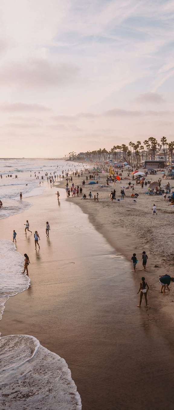 people walking on the beach at the ocean
