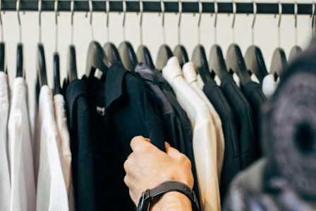 a person selecting clothes from a rack in a closet at The Hendry, Henderson, 89074