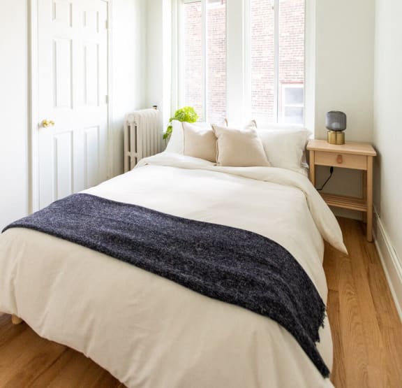 a bedroom with a bed and bookshelves     and a chair