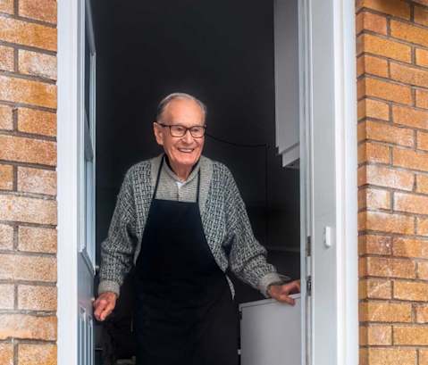 a man wearing an apron standing in a doorway