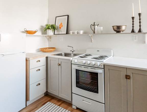 a kitchen with white cabinets and a stove and a sink