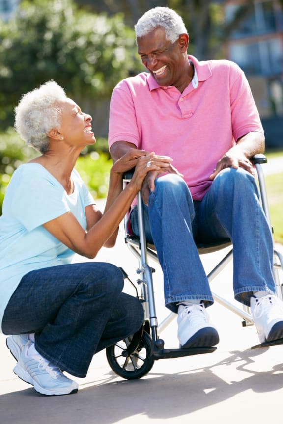 Man in wheelchair with woman kneeling beside him-Legacy Apartments, Pittsburgh, PA 15219