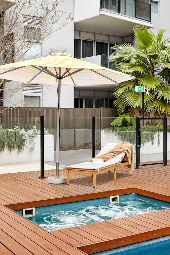 a swimming pool with a chaise lounge under an umbrella