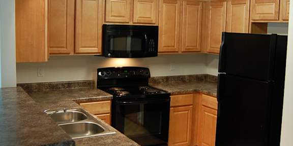 a kitchen with wooden cabinets and white appliances