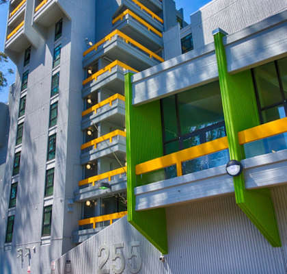 a view of a building with green and yellow balconies