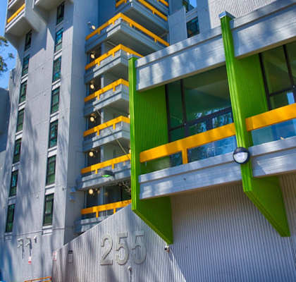 A modern building with a green and yellow balcony.