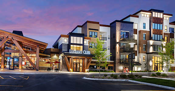 A large wooden structure is in front of a multi-story building.
