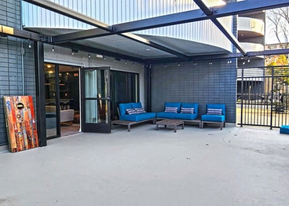 a patio with blue lounge chairs and a colorful painting on the wall