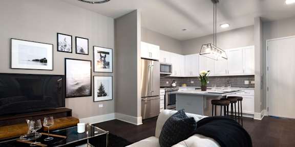 a living room and kitchen with a couch and a tv