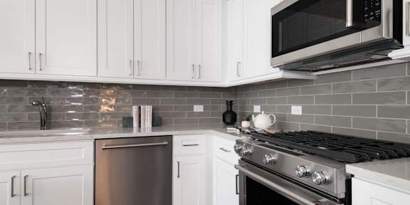 a kitchen with white cabinets and a stove and a microwave