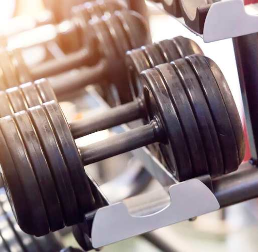 A close-up of a dumbbell on a rack in a gym.