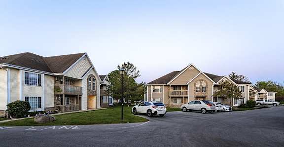 a row of houses with cars parked in front of them