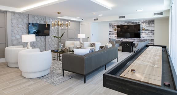 a living room with a shuffleboard table and couches