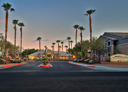 a street with houses and palm trees at sunset