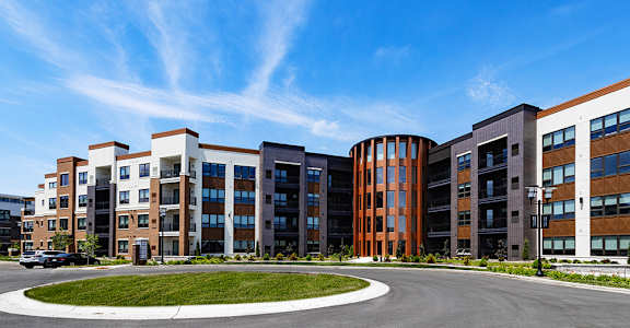 A large apartment complex with a roundabout in front.