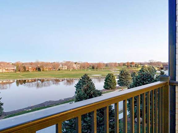 a view from a balcony overlooking a pond and the Wilderness Ridge Golf Course