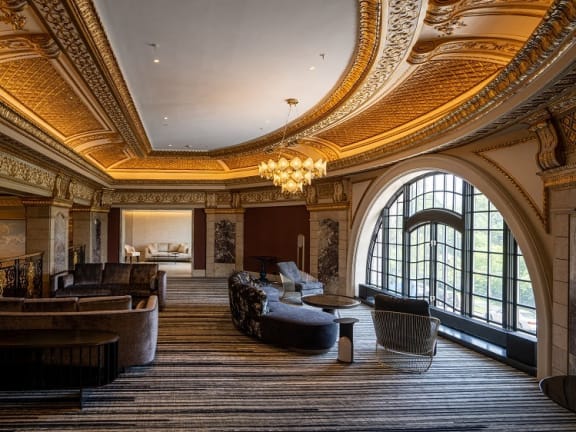 a large room with couches and chairs and a chandelier at the Belden Stratford in Chicago, 60614