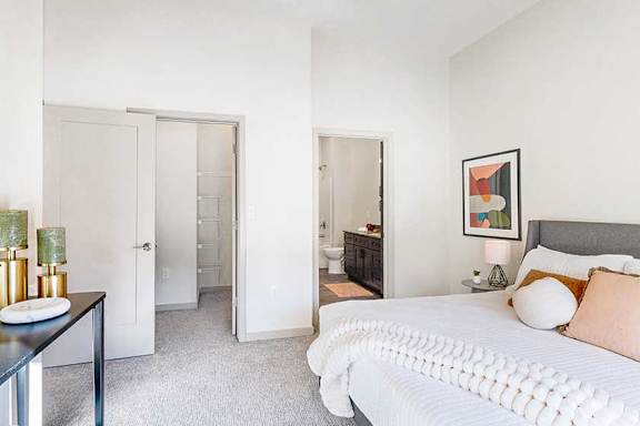 a bedroom furnished with modern furniture and a large window looking out to the courtyard