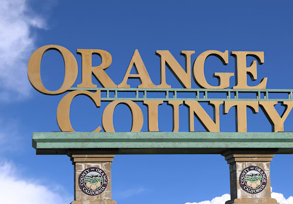 A sign that says Orange County with two clocks on each side. at The Orion Senior Apartments - Orange, CA Apartments, Orange, CA, 92866