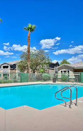 A large brown building with a pool in front.