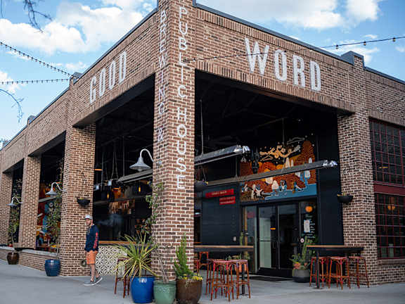 A man is standing outside a building with the word "WORD" on it.