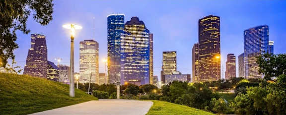 A city skyline at dusk with a walkway in the foreground.