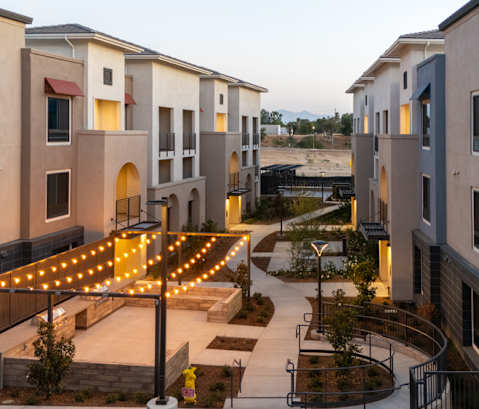 A modern apartment complex with a central courtyard and pathway.