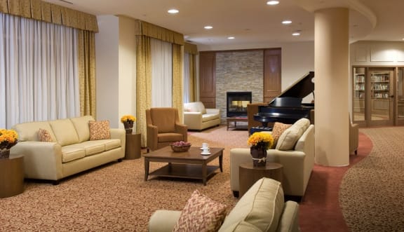 A large sitting room with couches and a grand piano.