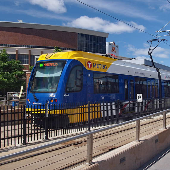 a blue and yellow train pulling into a station