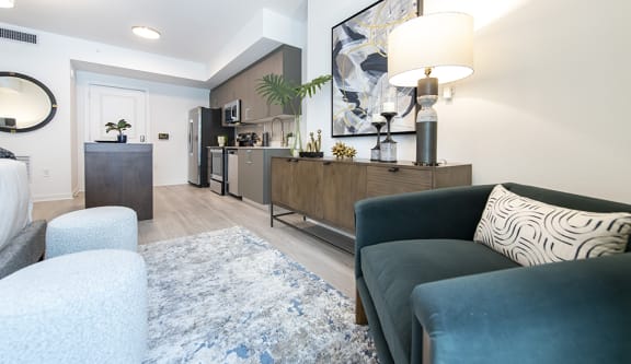 a living room with a couch and chair and a kitchen in the background