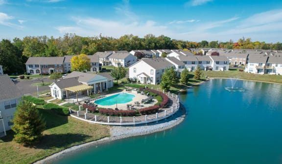 an aerial view of a resort with a pool and a lake