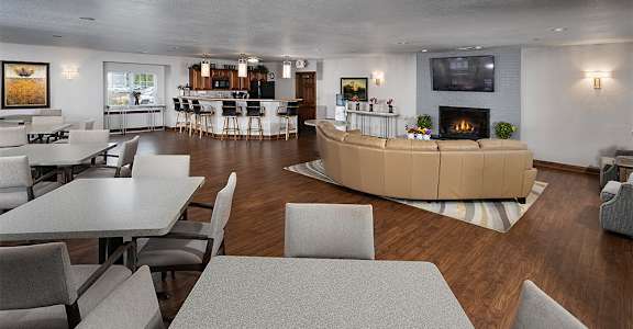a living room with tables and chairs and a fireplace