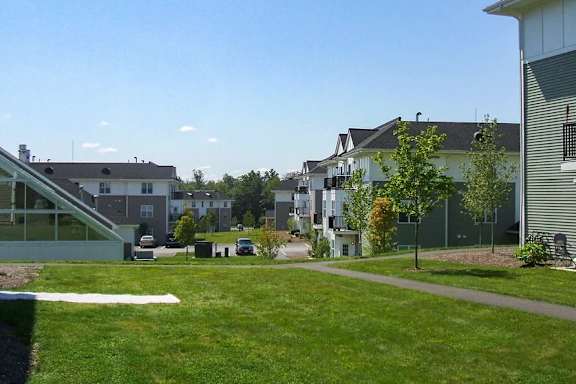 A grassy area in front of apartment buildings.