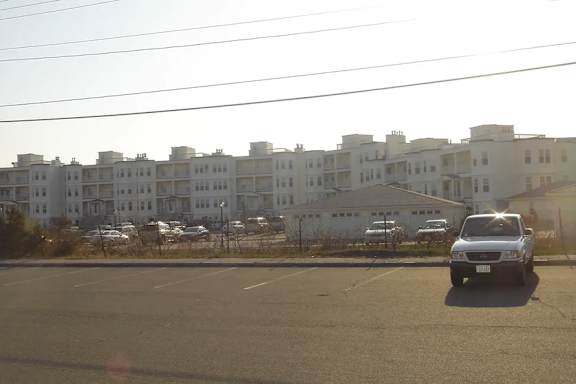 A white building with a parking lot in front of it.